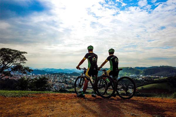 Dois atletas da Alpha Ciclo Racing Team no topo de uma montanha de MG